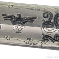 A World War II German dress bayonet with a polished blade, etched with the inscription “Zur Erinnerung an meine Dienstzeit,” decorative scrollwork, and a Wehrmacht eagle. The handle features stag horn grips, and the set includes a black-painted scabbard and leather frog.