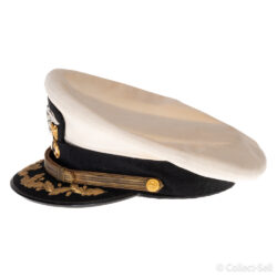 Side view of a U.S. Navy officer’s white combination cap, highlighting the curved black visor with gold embroidery, the gold chin strap, and the detailed side buttons.