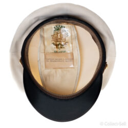 Interior of a U.S. Navy officer’s cap, showing a satin lining with a label that reads ‘Captain Archie C. Kuntze, CO, HEADSUPPACT, Saigon,’ along with a deluxe manufacturer’s logo.