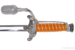 WWII German Army Officer’s Dagger featuring an orange celluloid grip, detailed Wehrmacht eagle crossguard, original silver portapee, polished blade, and pebbled metal scabbard with suspension rings