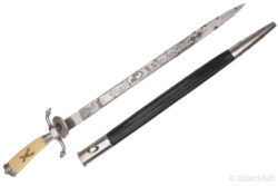 A WWII-era German hunting cutlass featuring an intricately etched blade with floral and hunting motifs, an ivory-colored grip with a crossed rifles emblem, and a black leather scabbard with metal fittings