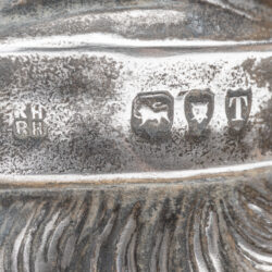 Close-up of hallmarks on 1894 Mr. Punch sterling silver cream jug, RH over RH, lion passant, leopard’s head, date letter T