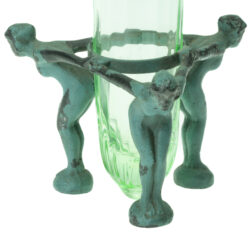 Three nude female figures in painted metal stand supporting uranium glass vase
